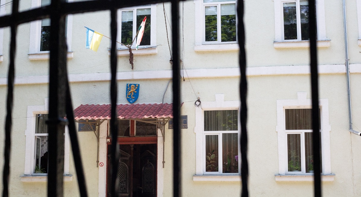 Школа в Берегово з українським та угорським прапорами на фасаді